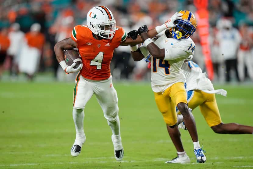 Miami running back Jaylan Knighton (4) runs for a first down as Pittsburgh defensive back...