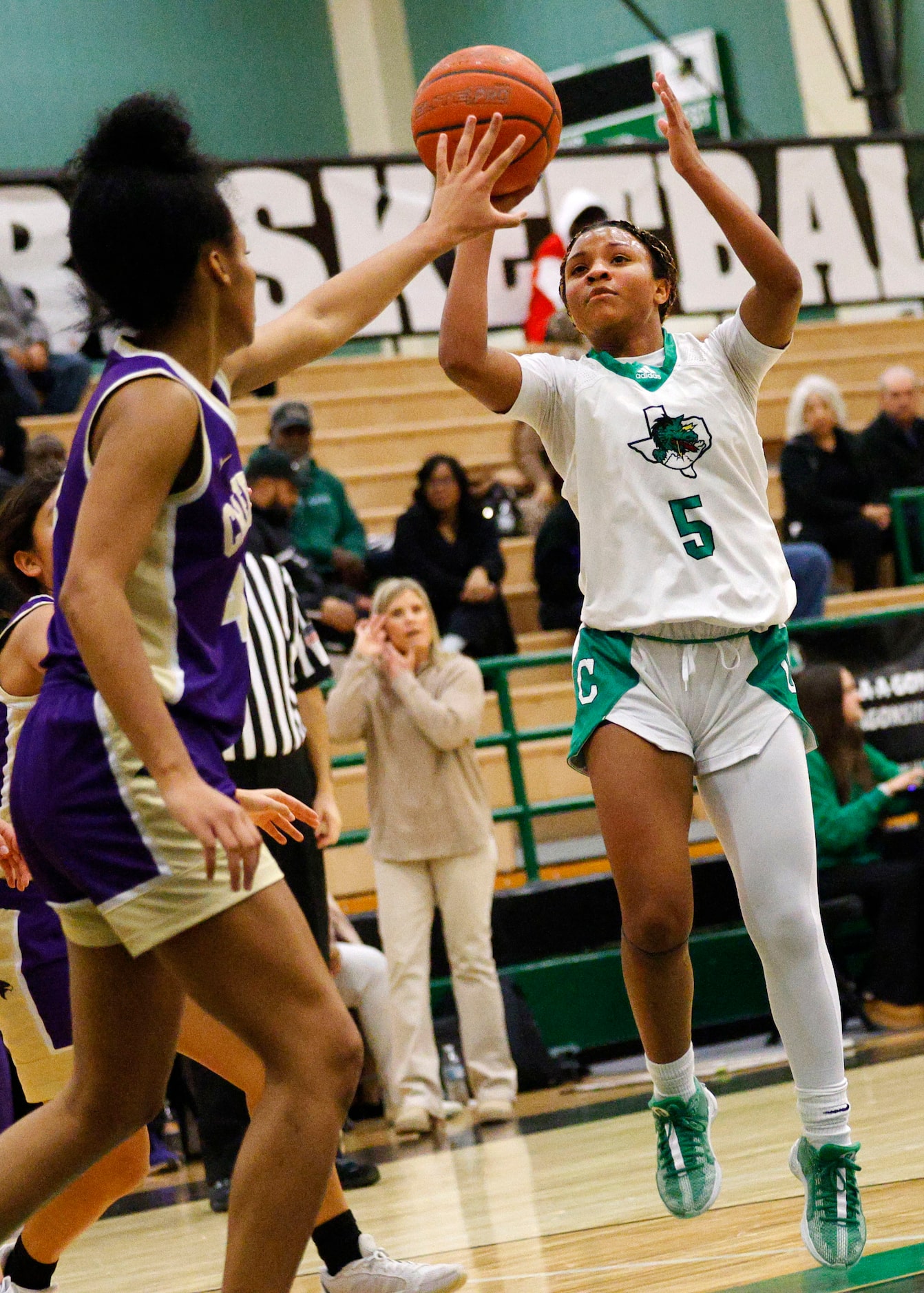 Southlake Carroll's Nadia Jordan (5) shoots over Keller Timber Creek's Jillian Topping (4)...