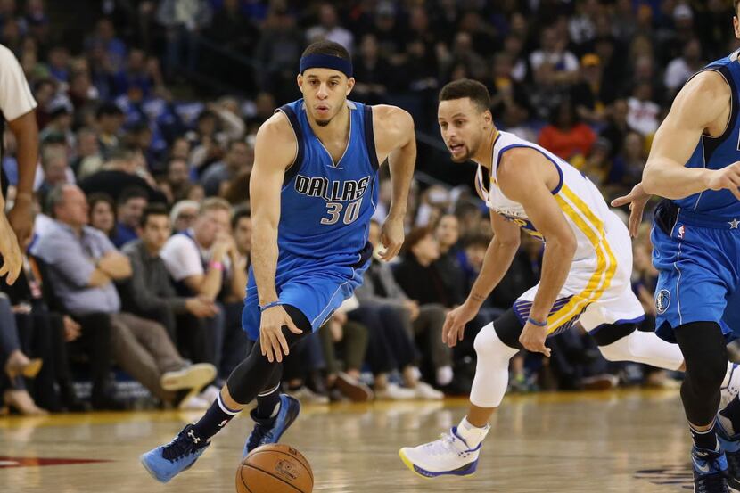 OAKLAND, CA - DECEMBER 30:  Seth Curry #30 of the Dallas Mavericks dribbles past his brother...