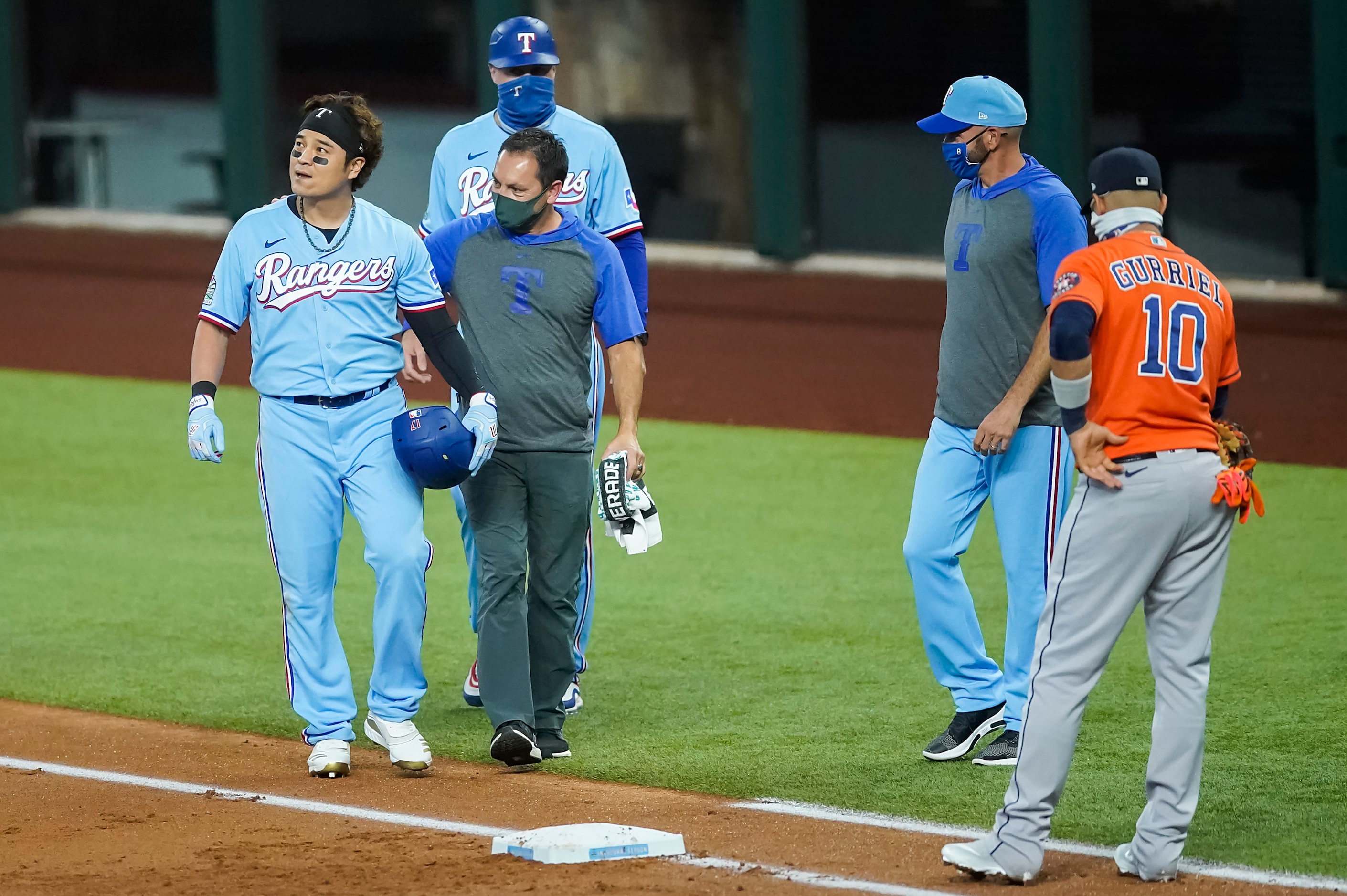 Texas Rangers designated hitter Shin-Soo Choo is checked on after he tumbled over the bag...