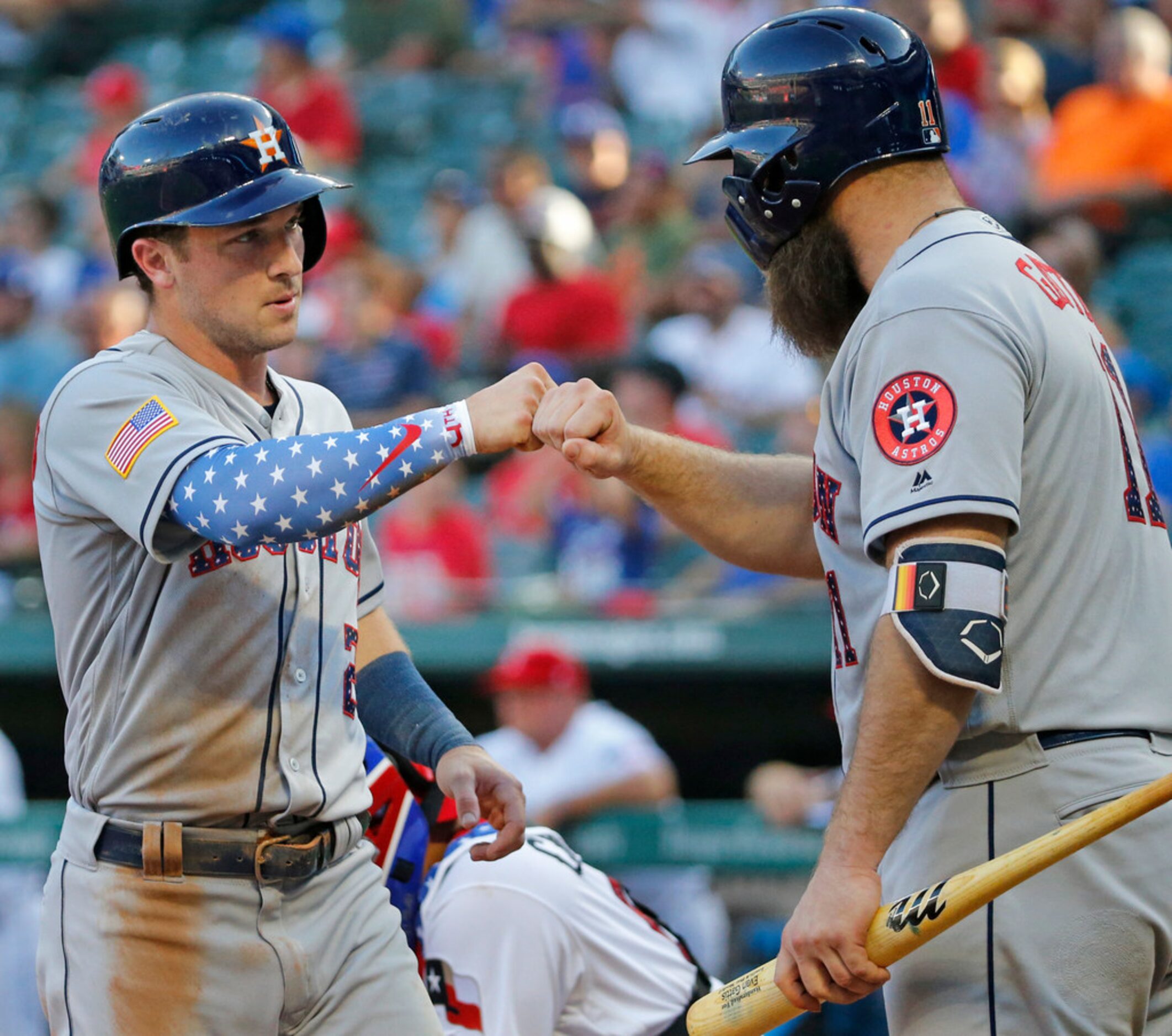 Houston Astros Alex Bregman (2) is congratulated by teammate Evan Gattis (11) after scoring...