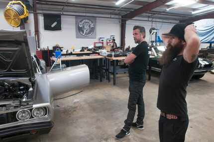 Richard Rawlings and Aaron Kaufman look at a car after filming a scene inside Gas Monkey...