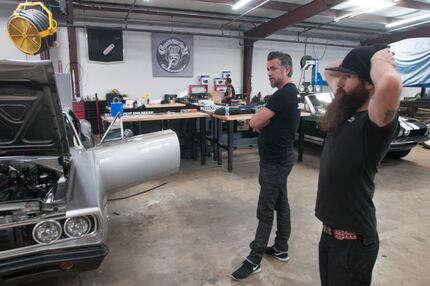 Richard Rawlings and Aaron Kaufman look at a car after filming a scene inside Gas Monkey...