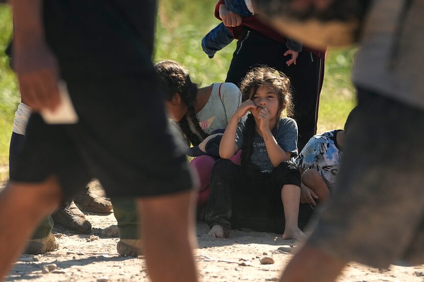 Migrants wait to be processed by the U.S. Customs and Border Patrol after they crossed the...