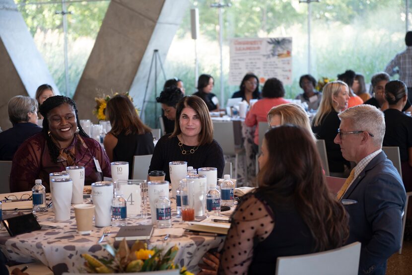 Perot Museum CEO Linda Silver sitting at table with other guests at the Perot Museum.