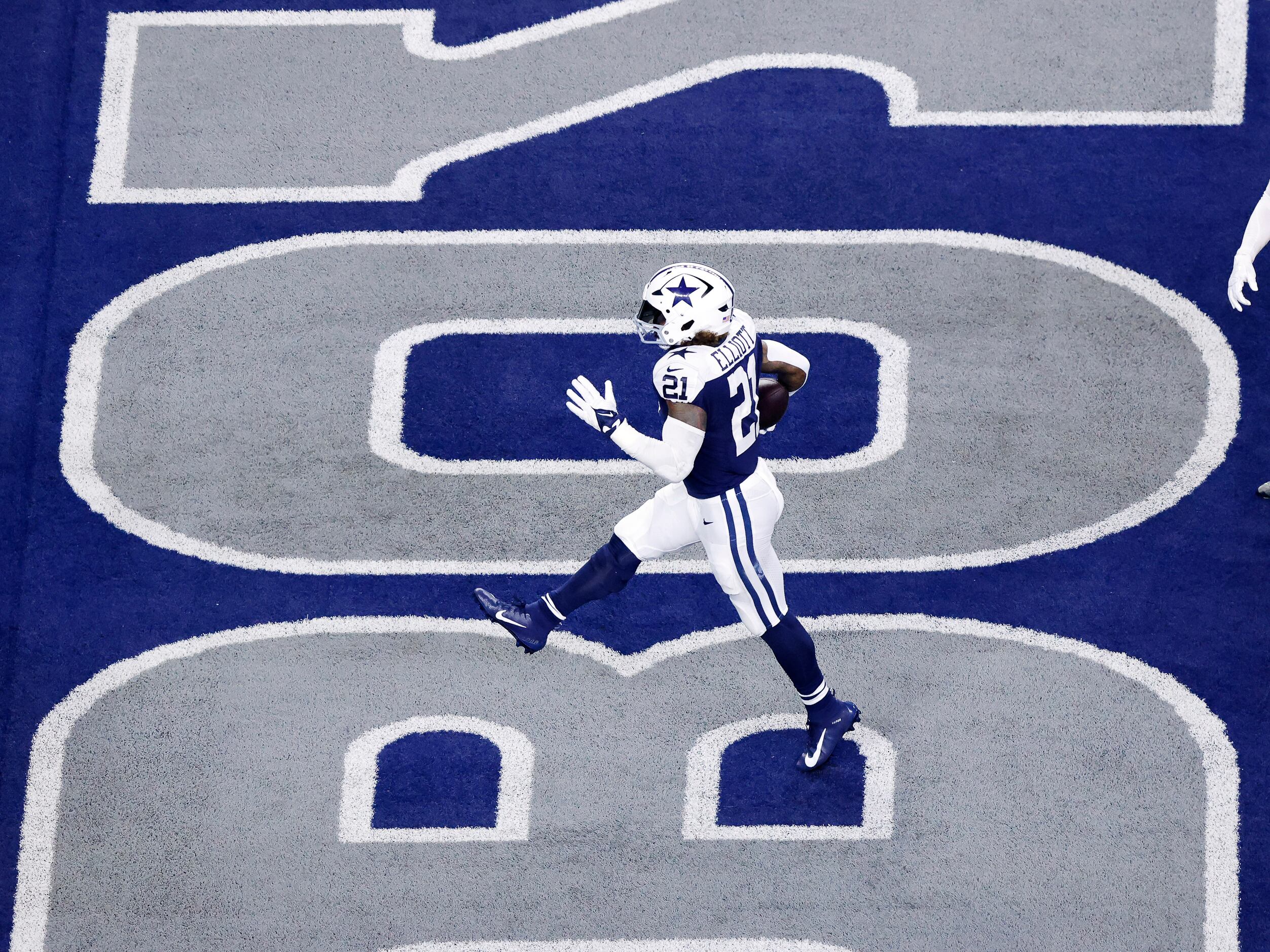 Dallas Cowboys running back Ezekiel Elliott (21) skips across the end zone as he scores a...