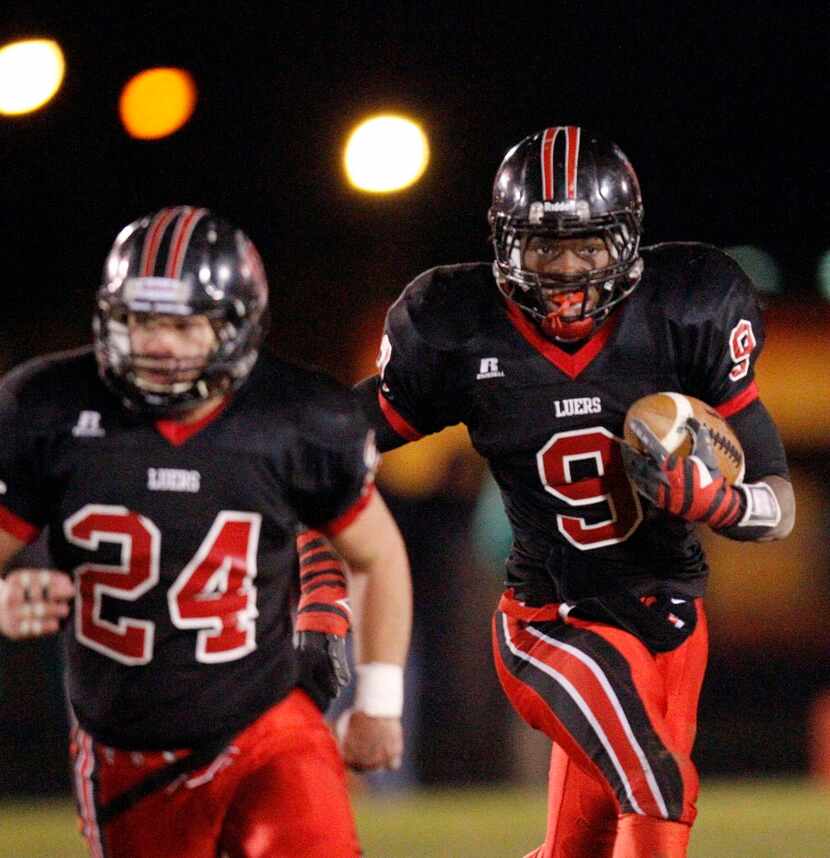 Bishop Luers High School running back Jaylon Smith, right, runs off the block of Logan...