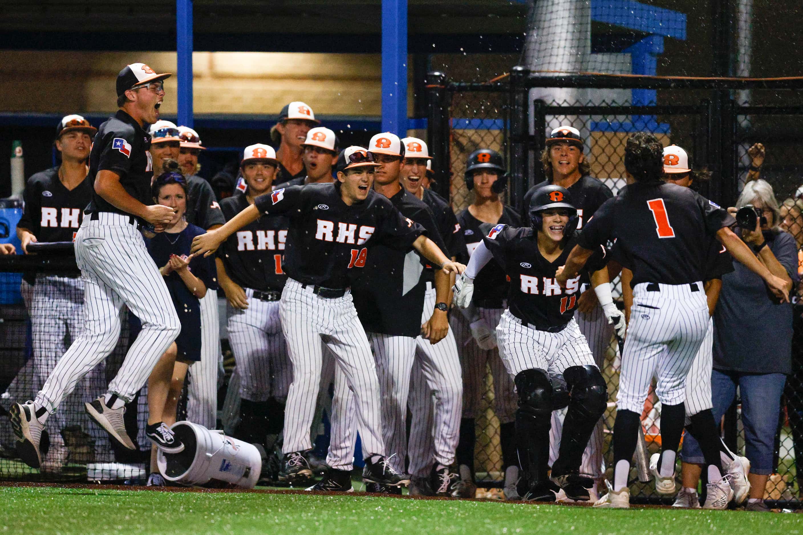 The Rockwall team celebrates a run by centerfielder Andrew Tellia (1) during the 8th inning...