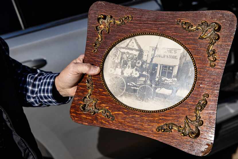 Virgil Thurmond holds a photo of the original Nitsche’s Flower Store.