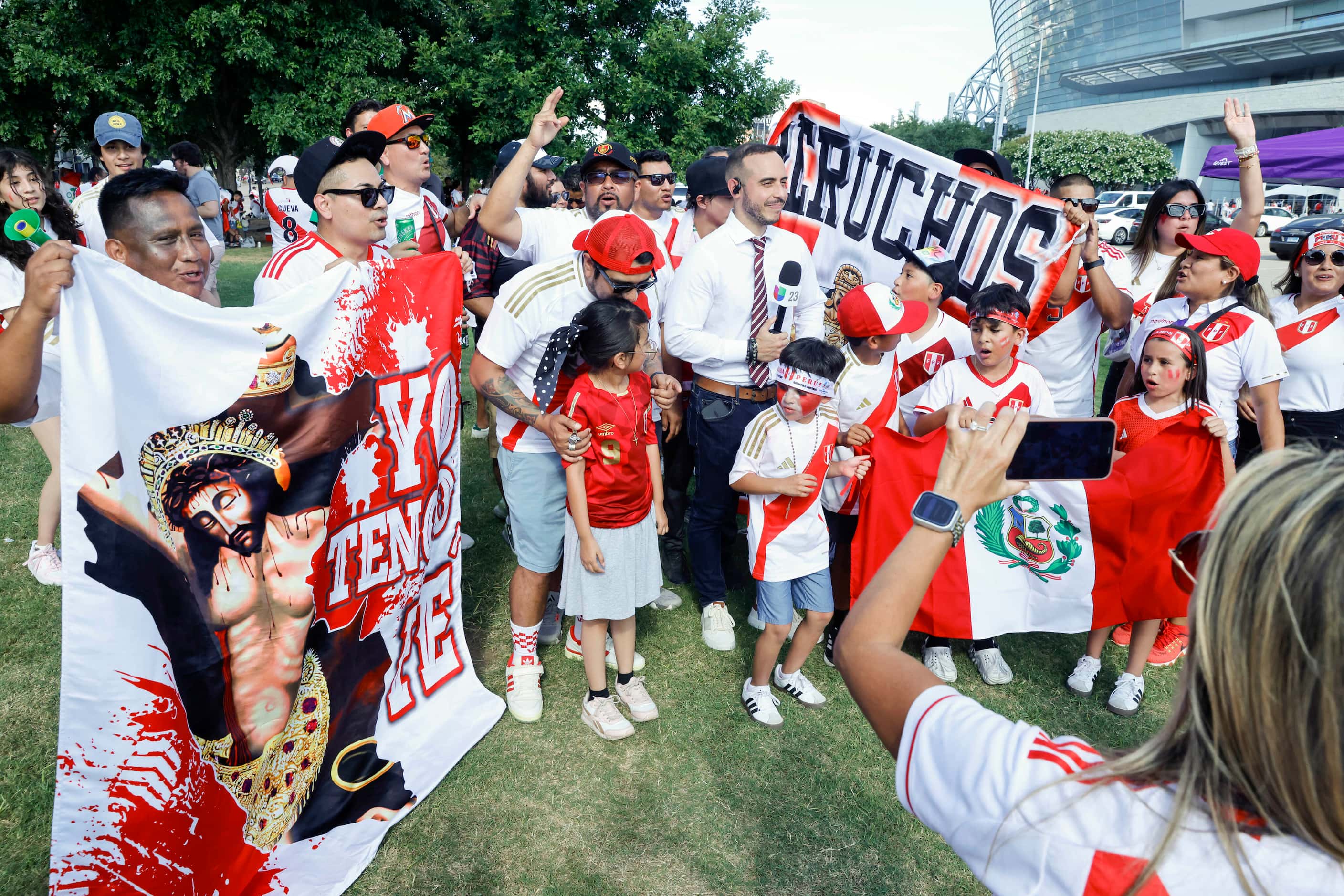 Peru fans cheer as a tv reporter films a live shot outside AT&T Stadium before a Copa...