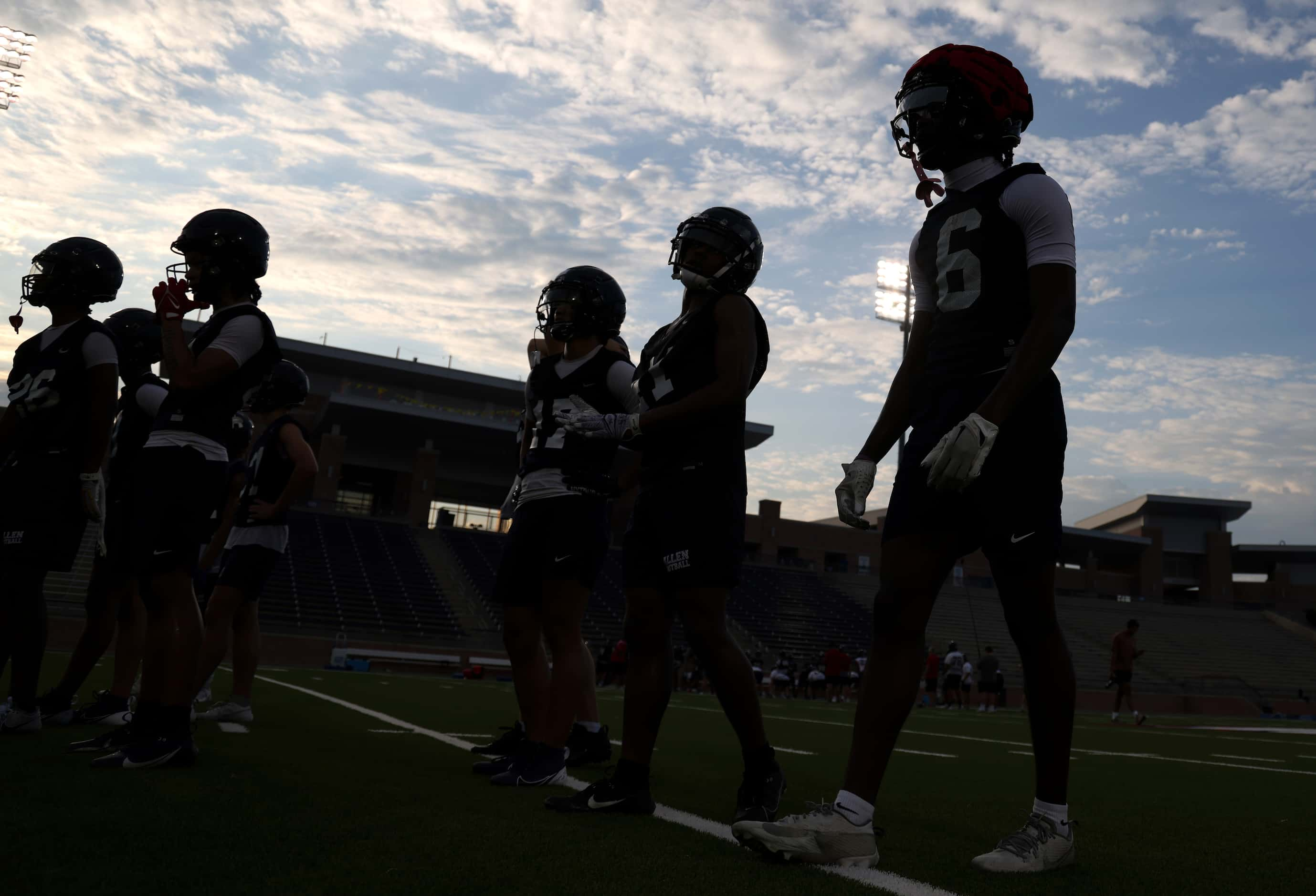 A group of Allen Eagles defensive backs await their turn to complete a drill during an early...