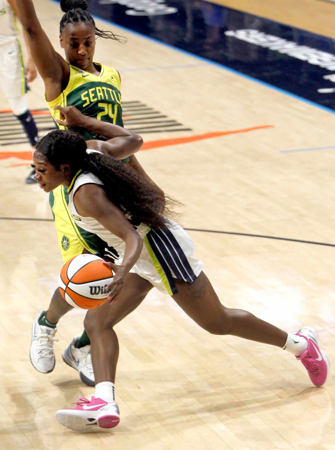 Dallas Wings guard Dana Evans (13) drives the baseline against the defense of Seattle guard...