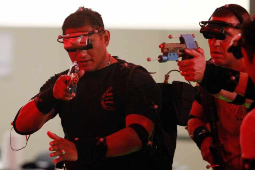 McKinney officers work a virtual reality scenario displayed by VIRTSIM equipment.