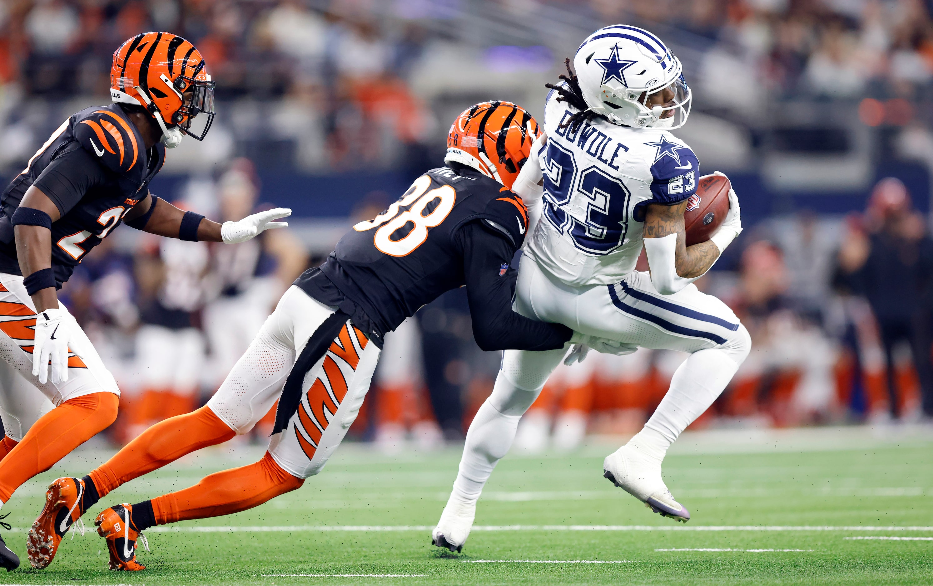 Dallas Cowboys running back Rico Dowdle (23) tries to spin out of the grasp by Cincinnati...