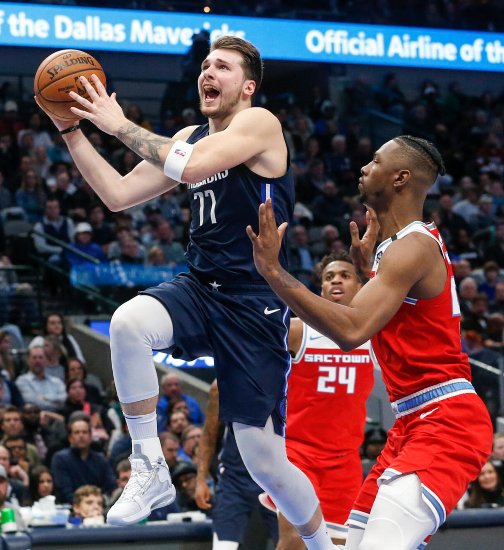 Dallas Mavericks guard Luka Doncic (77) goes up for a shot over Sacramento Kings forward...