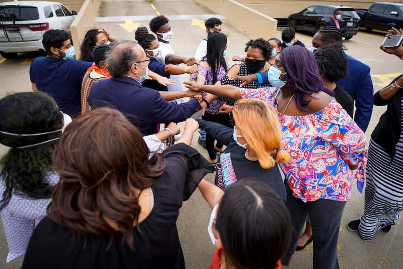 Students, parents and community organizers gather around activist Carlos Quintanilla as they...