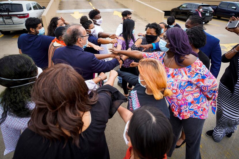 Students, parents and community organizers gather around activist Carlos Quintanilla as they...