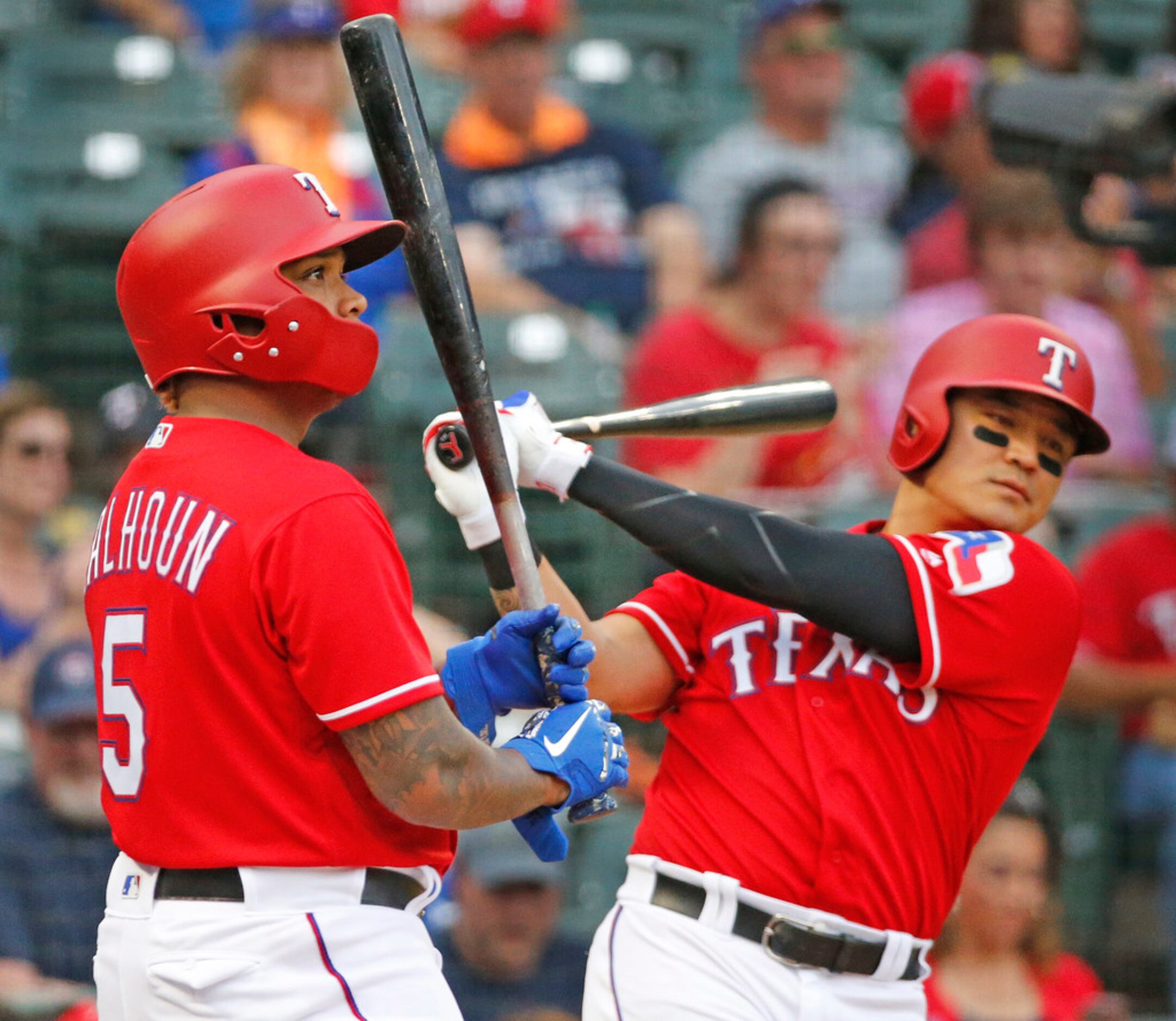 Texas Rangers Willie Calhoun (5) and  Shin-Soo Choo (17) warmup in the un deck area in the...