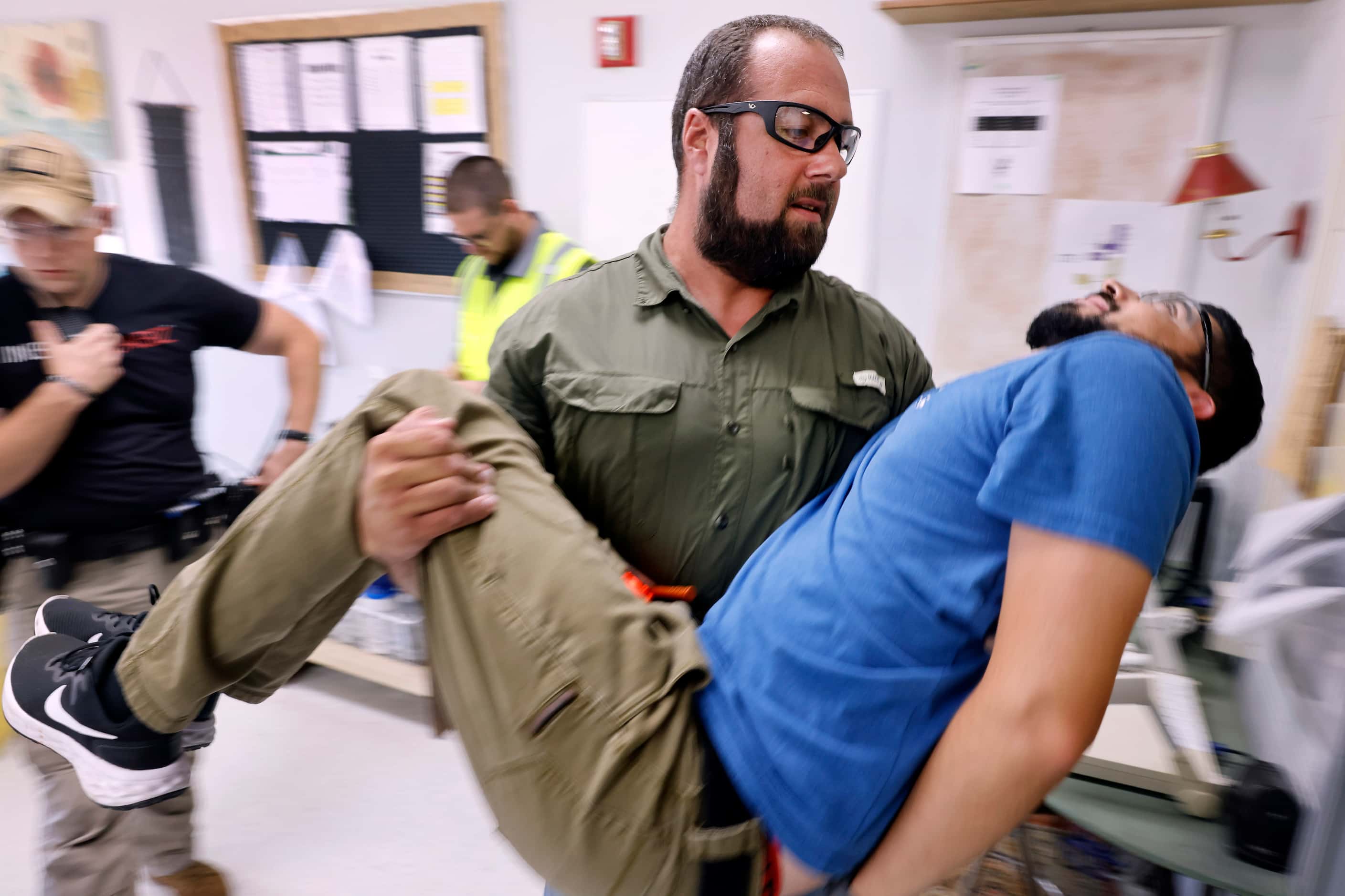 Henderson County Sheriff’s Deputy Mathew Jistel carries a wounded victim, portrayed by...