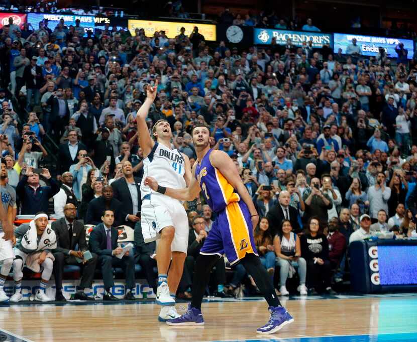 In front of his own bench, Dallas Mavericks forward Dirk Nowitzki (41) shoots and makes his...