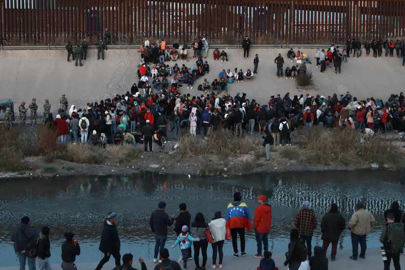 Immigrants gather along the border near El Paso.