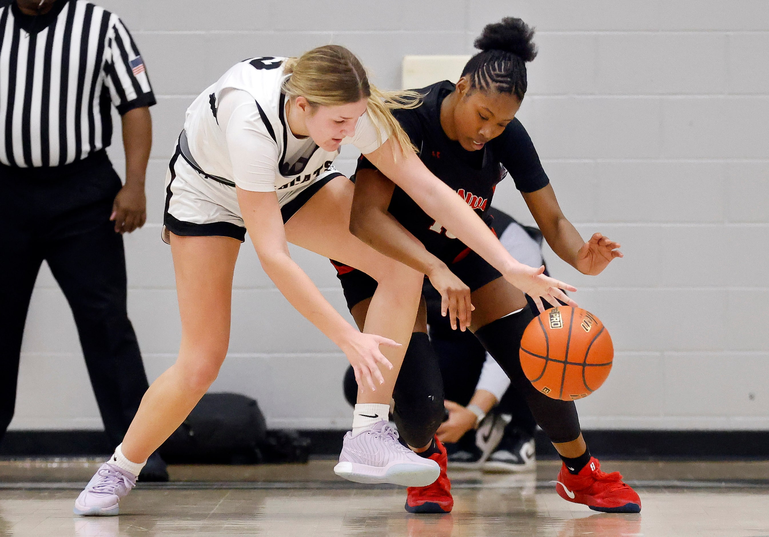 Denton Guyer forward Audrey Mitchell (12) and Denton Braswell guard Makayla Vation (15)...