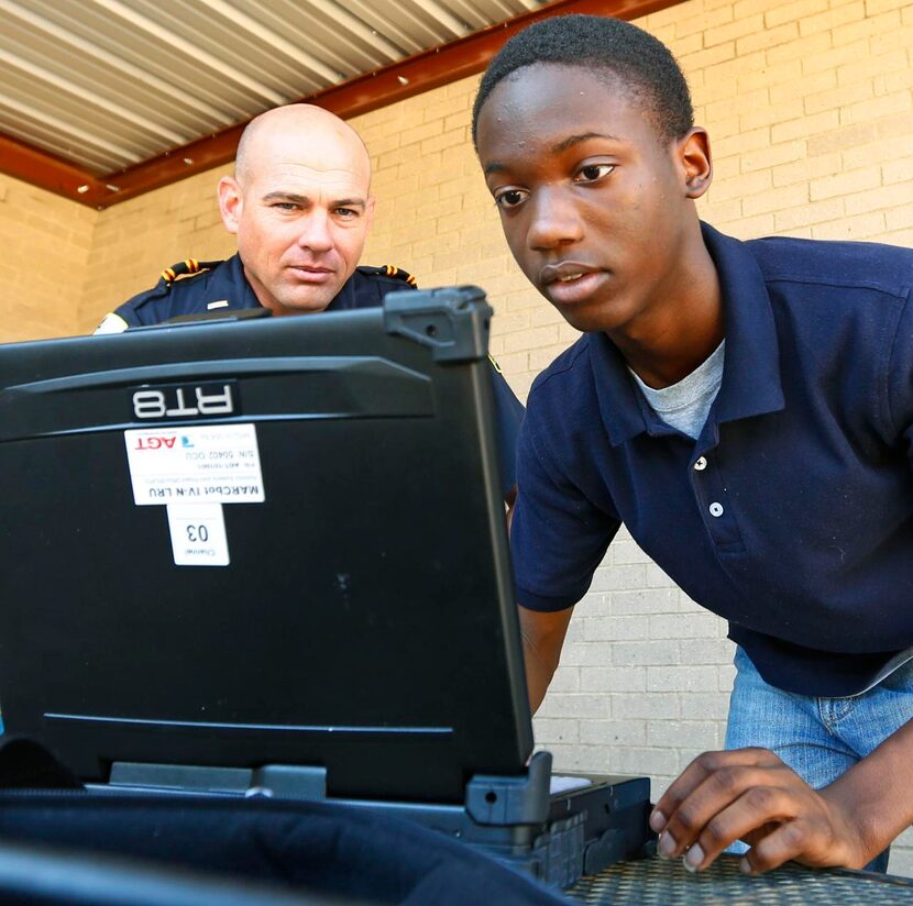 
Duncanville Police Department's Lt. Gene Kropff, left, and Adrian Mayberry, 17, set up the...