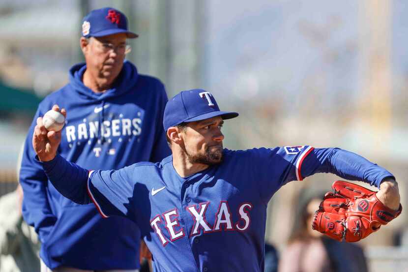 Texas Rangers right handed pitcher Nathan Eovaldi practices as special assistant Greg...