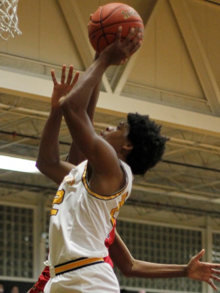 Garland guard Chauncey Carter (22) drives the lane and shoots over the defense of a North...