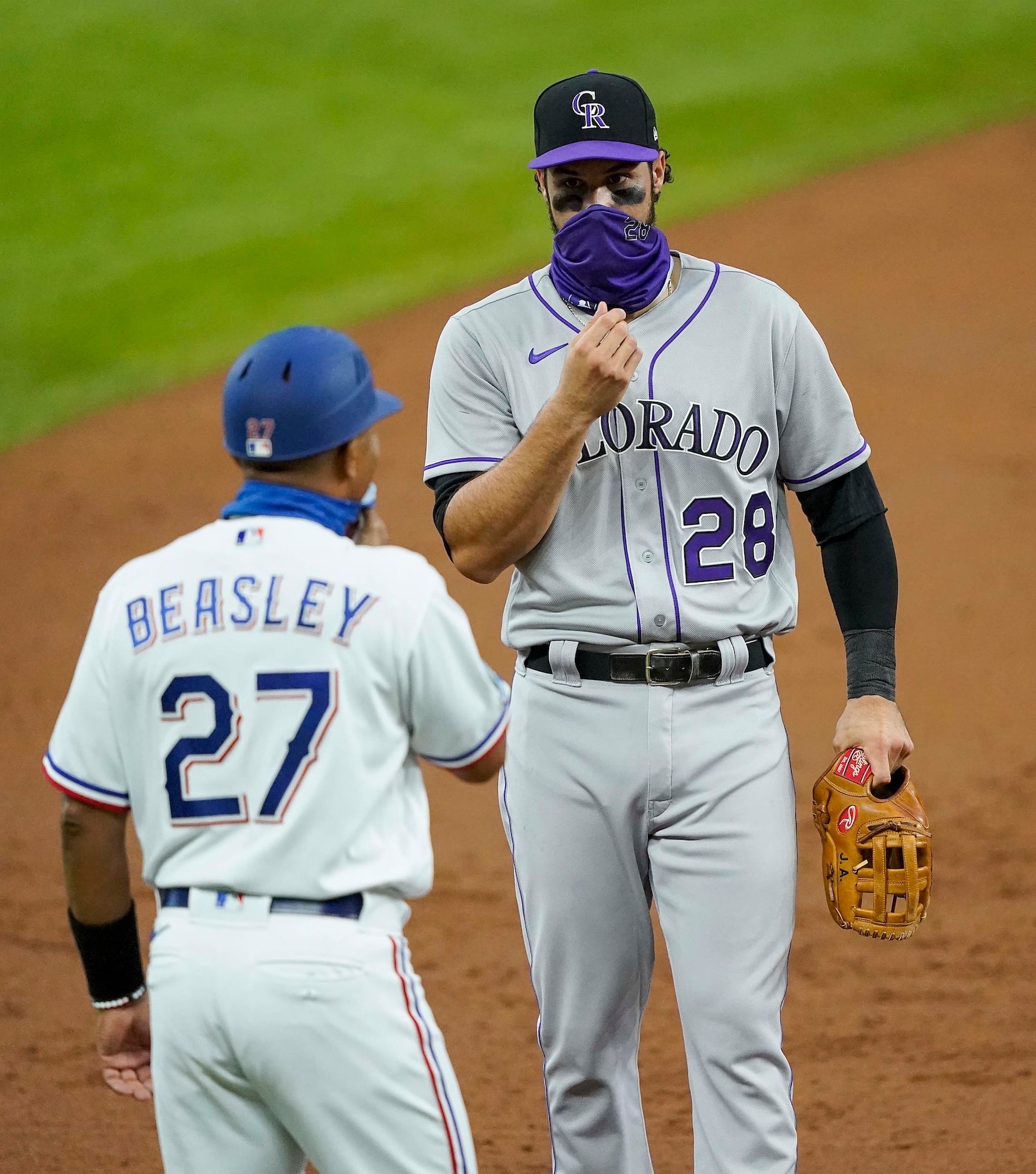 Texas Rangers third base coach Tony Beasley chats with Colorado Rockies third baseman Nolan...