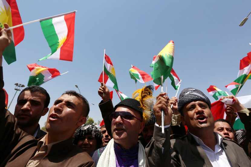 Iraqi Kurdish protesters wave flags of their autonomous Kurdistan region during a...
