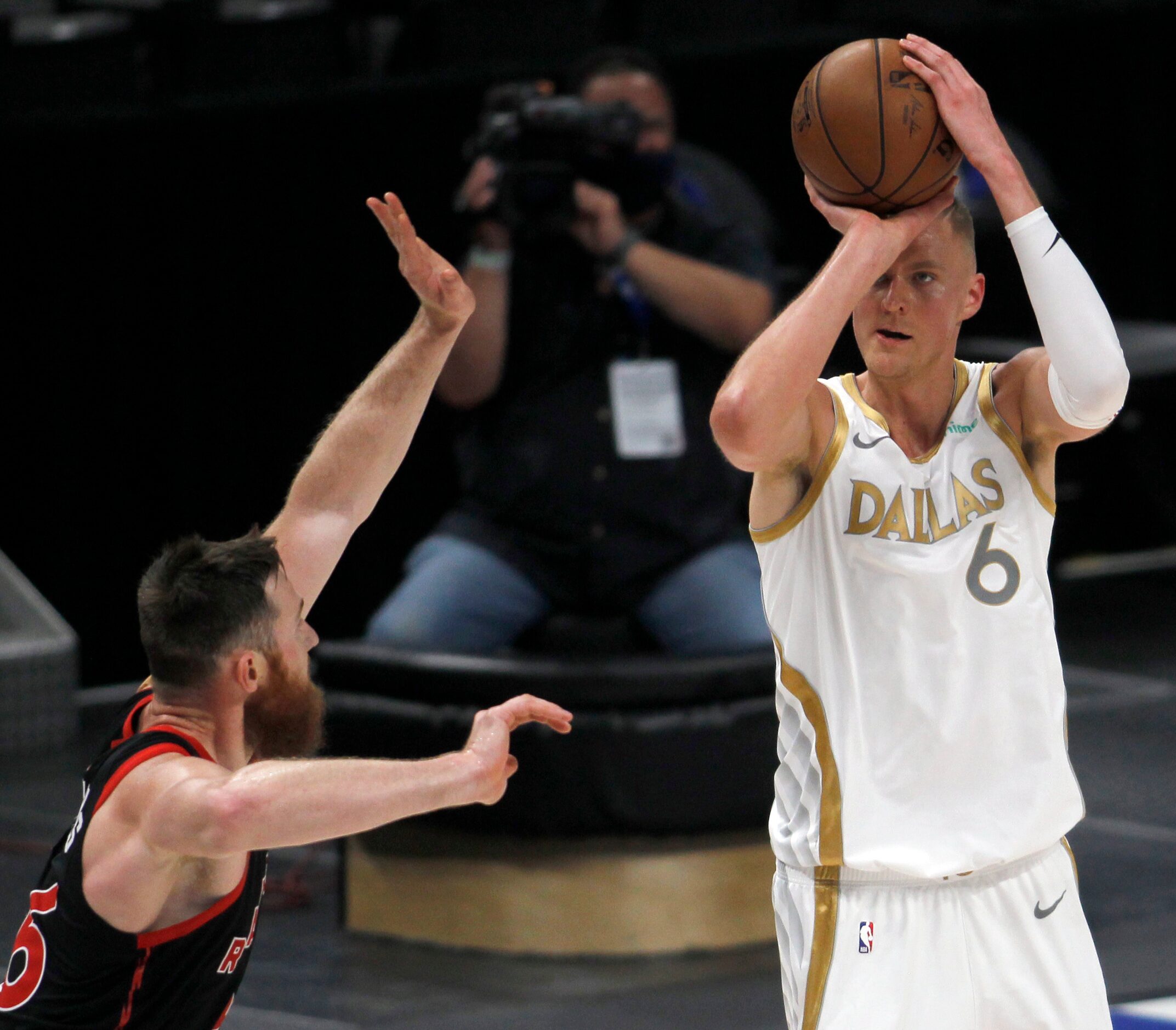 Dallas Mavericks center Kristaps Porzingas (6) sinks a jump shot over the defense of Toronto...