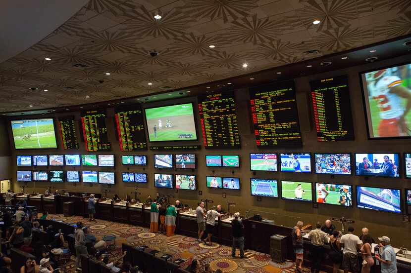 FILE - People place bets on sports at the MGM Grand Race & Sports Book in Las Vegas, Aug....
