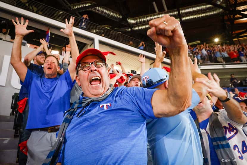 Texas Rangers fan Jamie Furrate reacts after Corey Seager hit a game-tying two-run home run...