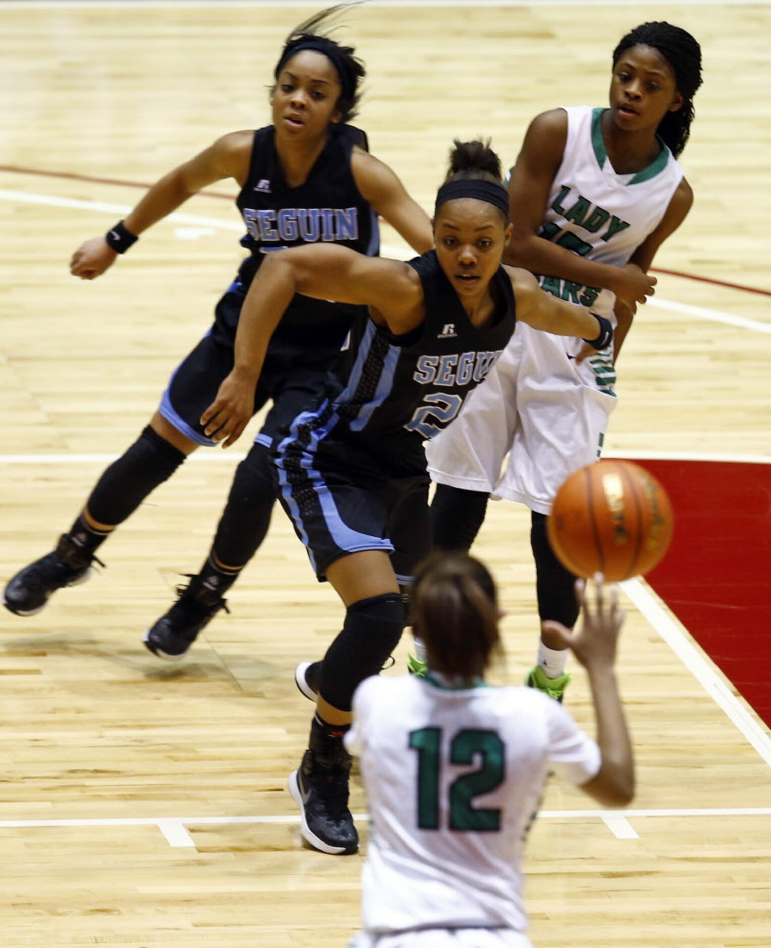 Bryan Adams' Alexxus Gilbert (12) tries to pass to DeBrashia Baty (15) as Arlington Seguin's...