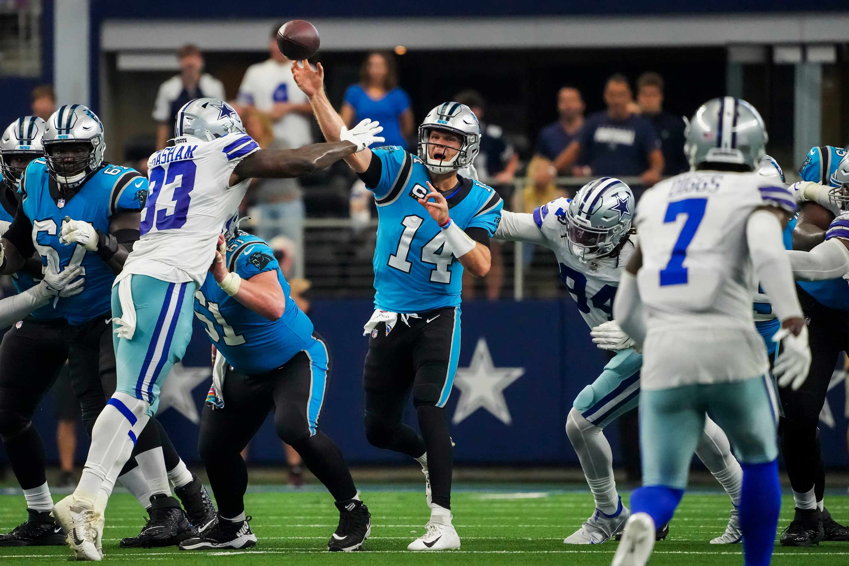 Carolina Panthers quarterback Sam Darnold (14) throws a pass under pressure from Dallas...