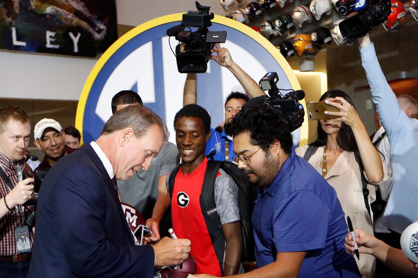 Texas A&M head coach Jimbo Fisher signs autographs as he arrives at the Southeastern...
