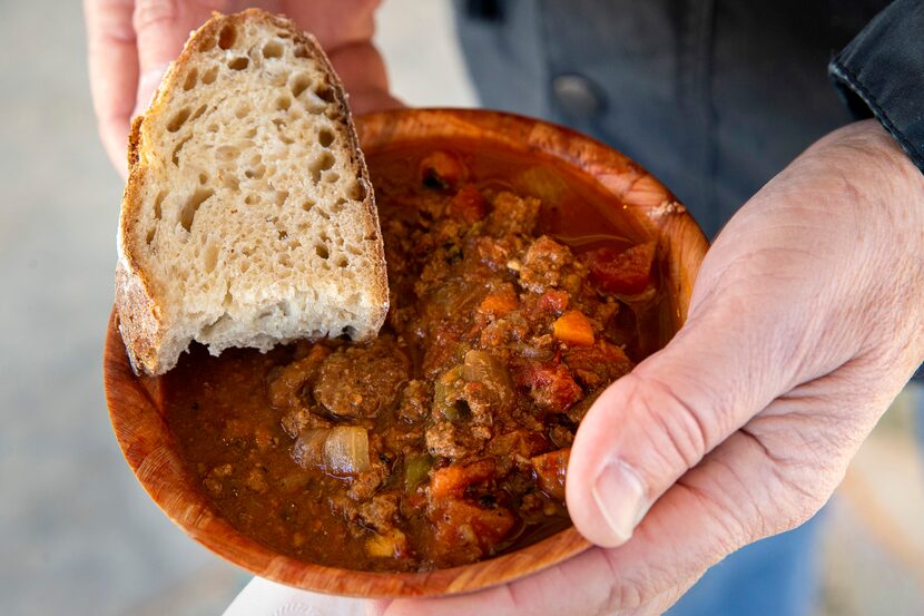 A man holds locally sourced bison chili provided to paying attendees of a bison field...