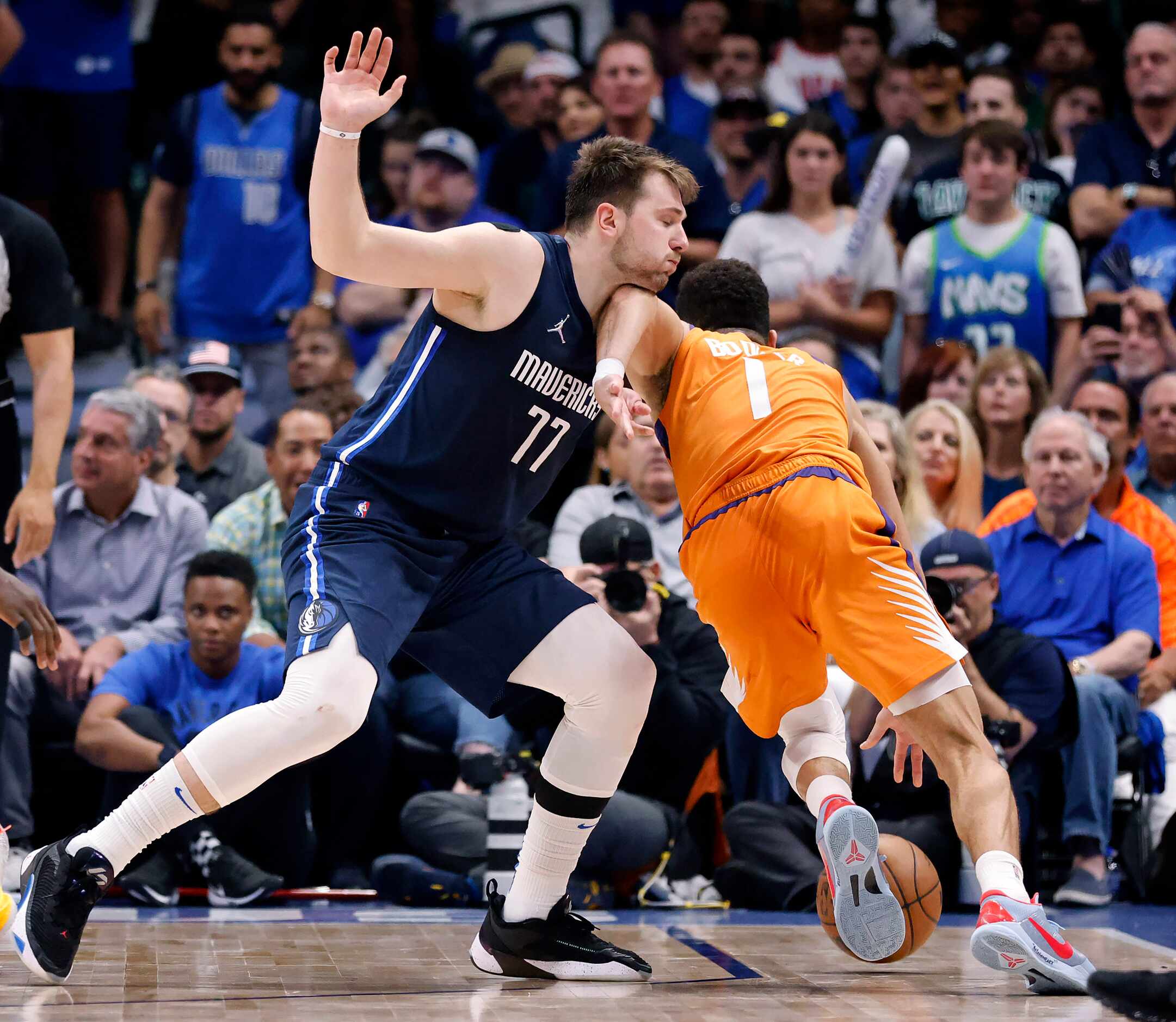 Phoenix Suns guard Devin Booker (1) is called for an offensive foul as he drives into Dallas...