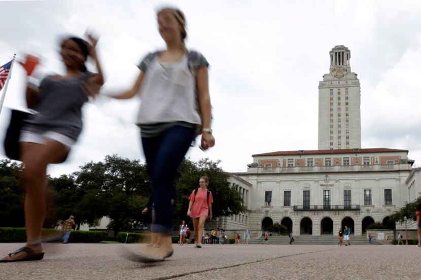  Students walk through the University of Texas campus near the school's iconic tower in...