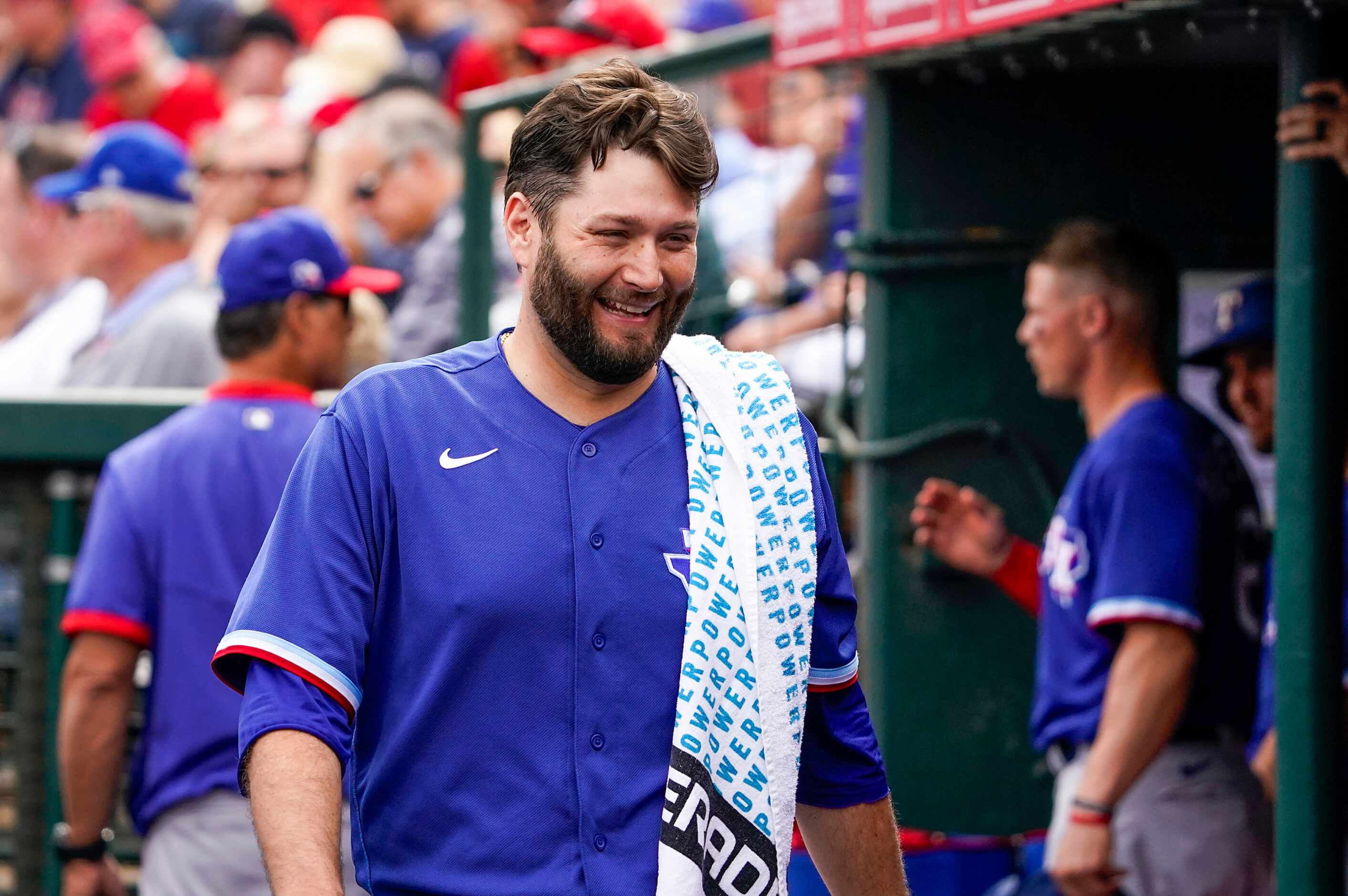 Texas Rangers pitcher Lance Lynn laughs with teammates in the dugout during the second...