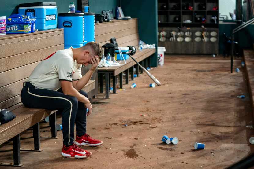 Texas Rangers relief pitcher Glenn Otto sits on the dugout bench during the sixth inning of...