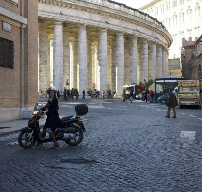 Knight gets around Rome on a Honda scooter, like the locals. The colonnade in the background...