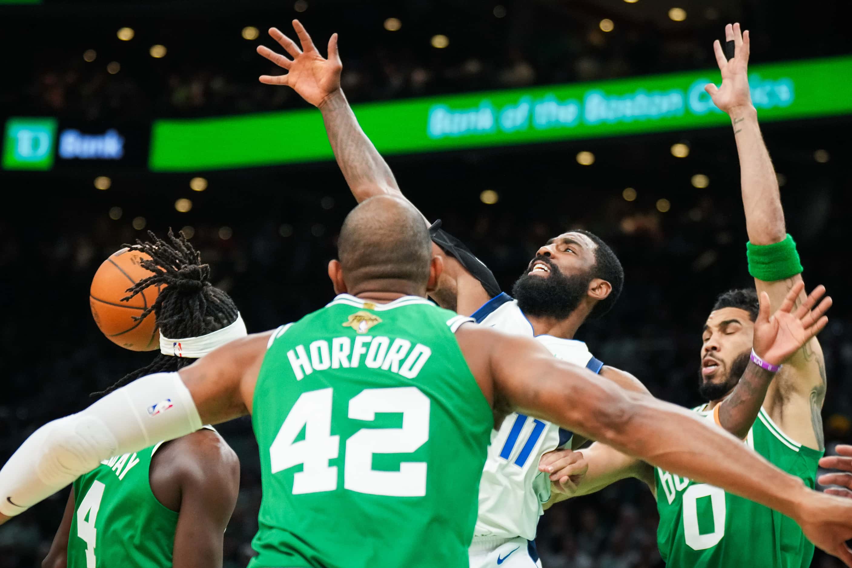 Dallas Mavericks guard Kyrie Irving (11) turns the ball over between Boston Celtics guard...