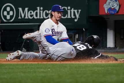 Chicago White Sox's Luis Robert Jr. (88) is tagged out at home plate by Texas Rangers...