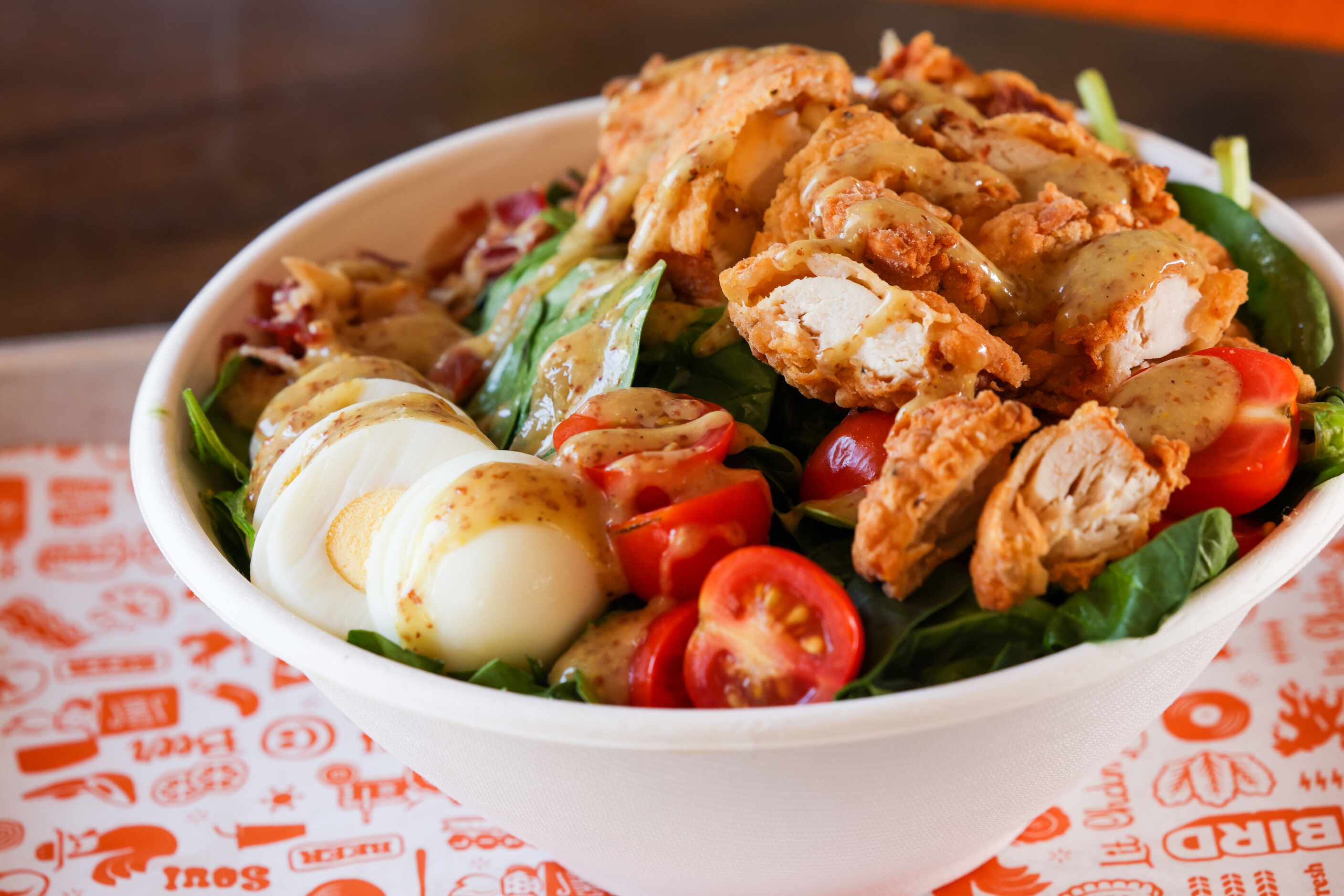 Soul Bird menu options include Chkn Shack salad, made with baby spinach, caramelized onions,...