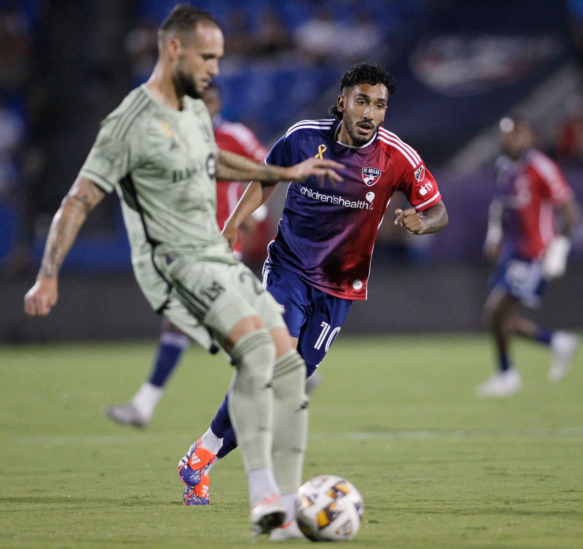 FC Dallas attacker Jesus Ferreira (10), background, moves in defensively as an LAFC player...