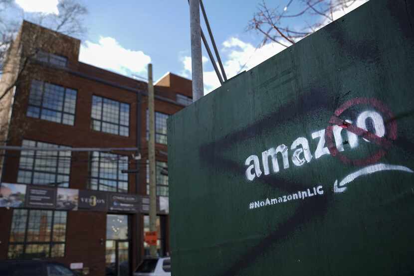 Someone has spray-painted a protest message against Amazon  on a wall near a construction...