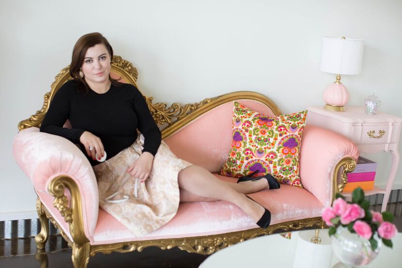 Owner Zsofia Mezey lounges on a pink crushed velvet loveseat in Zsofia's front waiting area....