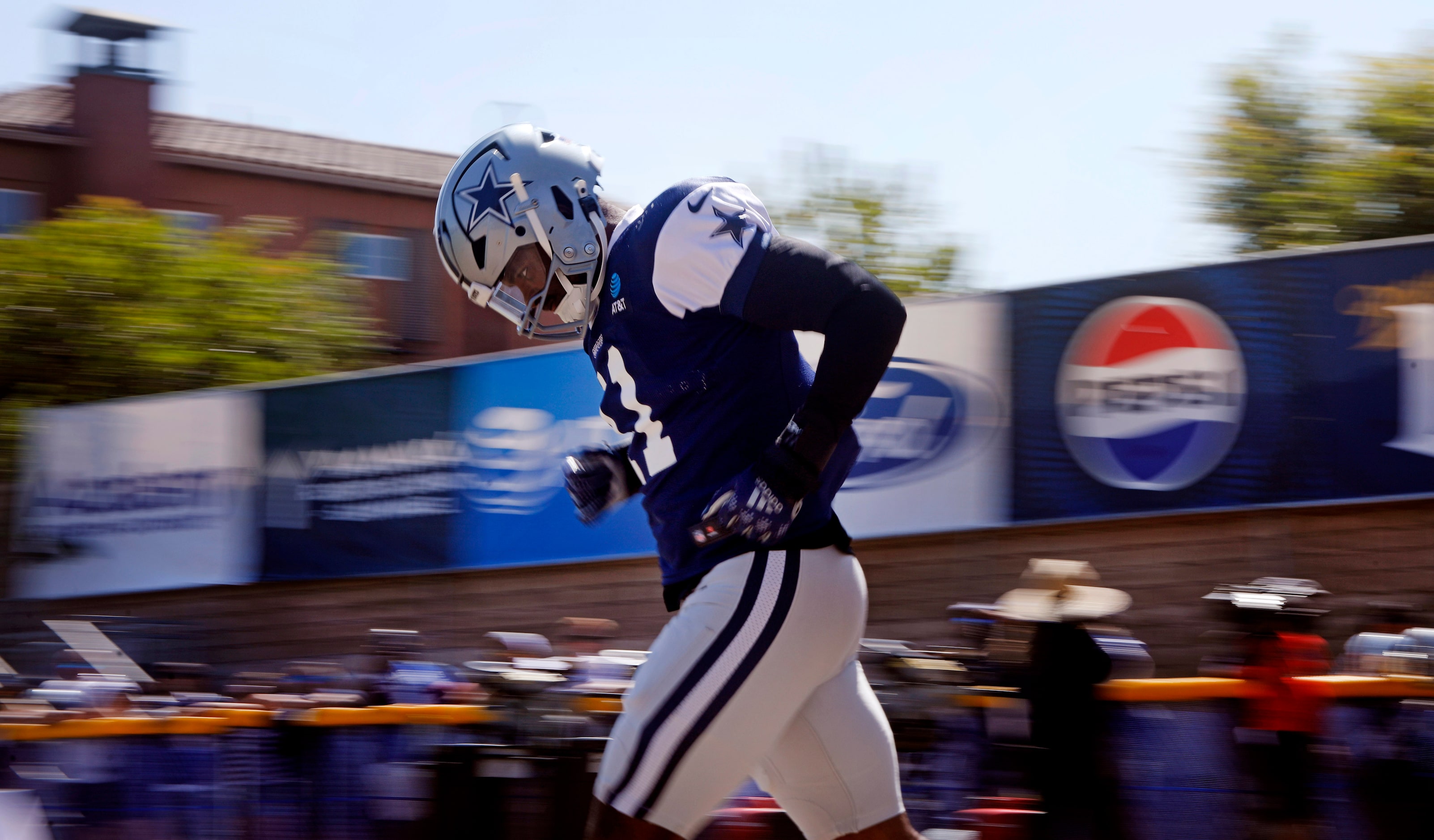 Dallas Cowboys linebacker Micah Parsons (11) jogs to the fields for the start of training...